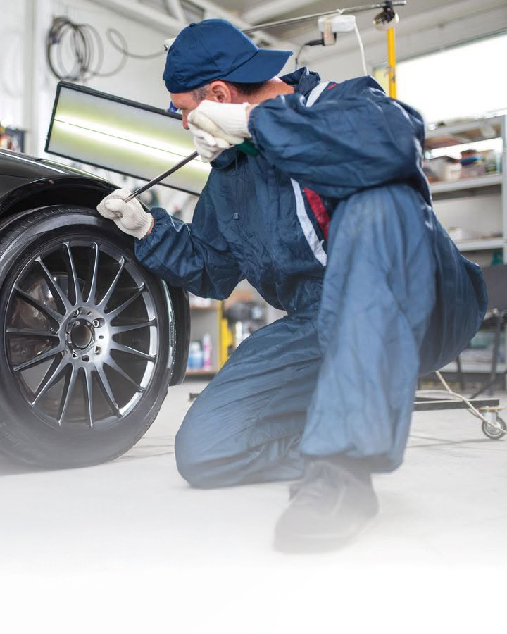Technicien en carrosserie effectuant une réparation de précision sur un véhicule